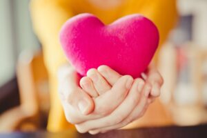 A woman hands is holding a pink heart, love valentine concept